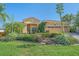 Charming home featuring a terra cotta roof, lush landscaping, and verdant lawn at 6600 Horned Owl Pl, Sarasota, FL 34241