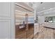 Stainless steel refrigerator with custom cabinet surround, seamlessly integrated into the open kitchen and living area design at 6600 Horned Owl Pl, Sarasota, FL 34241