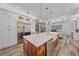 Spacious kitchen featuring a large island, stainless steel fridge, and view to living room fireplace, perfect for modern living at 6600 Horned Owl Pl, Sarasota, FL 34241