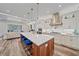 Open-concept kitchen with island, marble countertops, and stainless appliances flows into a living area, perfect for gathering at 6600 Horned Owl Pl, Sarasota, FL 34241