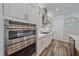 Gourmet kitchen featuring stainless steel appliances and sleek white cabinetry with gold hardware at 6600 Horned Owl Pl, Sarasota, FL 34241