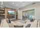 Inviting living room with a cozy fireplace, a large sectional sofa, and access to the outdoor patio at 6600 Horned Owl Pl, Sarasota, FL 34241