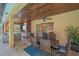 Outdoor dining area with wood ceiling, ceiling fans, and view of the screened-in pool at 6600 Horned Owl Pl, Sarasota, FL 34241