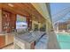 Outdoor kitchen with granite countertops, a bar, a TV, and access to the screened-in pool at 6600 Horned Owl Pl, Sarasota, FL 34241