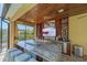 Outdoor kitchen bar with granite countertops, seating, TV and bottle and glass storage at 6600 Horned Owl Pl, Sarasota, FL 34241