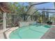 Screened-in pool area featuring a beautiful pool with water feature and lush tropical landscaping at 6600 Horned Owl Pl, Sarasota, FL 34241