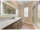 Bathroom featuring sleek vanity with quartz countertop and modern frameless glass shower at 7913 Osprey Hammock Ct, Sarasota, FL 34240