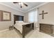Bedroom with a dark wood frame bed and dresser on gray carpet at 7913 Osprey Hammock Ct, Sarasota, FL 34240