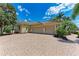 Spacious three-car garage with a brick-paved driveway and well-maintained landscaping at 7913 Osprey Hammock Ct, Sarasota, FL 34240
