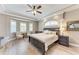 Comfortable main bedroom with a tray ceiling, bay windows, and hardwood floors at 7913 Osprey Hammock Ct, Sarasota, FL 34240