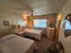 Cozy bedroom featuring two twin beds, wood paneling, and a ceiling fan at 808 53Rd E Ave # 234, Bradenton, FL 34203