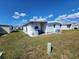 Bright, white mobile home with red roof featuring vinyl siding, a small lawn and neighborhood views at 808 53Rd E Ave # 234, Bradenton, FL 34203
