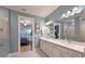 Bright bathroom featuring double vanity, quartz countertops, and access to the bedroom at 8722 Backshore Ln, Parrish, FL 34219