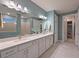 Bathroom featuring a double vanity, large mirror, and a separate walk-in closet at 8722 Backshore Ln, Parrish, FL 34219