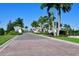 Landscaped community entrance with stately columns, lush greenery, and palm trees, for a grand arrival at 8722 Backshore Ln, Parrish, FL 34219