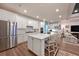 Gourmet kitchen featuring stainless steel appliances, a large center island, and custom white cabinetry at 8722 Backshore Ln, Parrish, FL 34219