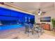Screened patio with dining table, view of lit pool and serene lake at twilight at 8722 Backshore Ln, Parrish, FL 34219
