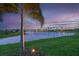 Scenic pond view with palm trees and a colorful sunset in a peaceful neighborhood at 8722 Backshore Ln, Parrish, FL 34219