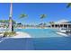 Inviting zero-entry pool with clear blue water, surrounded by palm trees and comfortable lounge chairs at 8722 Backshore Ln, Parrish, FL 34219
