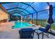 Screened-in pool area with lounge chairs and lush landscaping, perfect for relaxation at 8722 Backshore Ln, Parrish, FL 34219