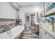 Stylish bathroom featuring wood plank tile, a claw foot tub, double sink vanity, and glass enclosed shower at 9011 Hilolo Ln, Venice, FL 34293