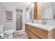 Stylish bathroom featuring wood plank tile, glass enclosed shower, and double sink vanity at 9011 Hilolo Ln, Venice, FL 34293