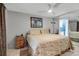 Bright bedroom featuring a ceiling fan and adjacent bathroom view at 9011 Hilolo Ln, Venice, FL 34293