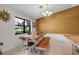 Dining area enhanced by the natural light, rustic wood table, bench and chairs, and neutral wall at 9011 Hilolo Ln, Venice, FL 34293