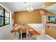 Dining area with wood furniture, bench seating, a view from the window and warm wall colors at 9011 Hilolo Ln, Venice, FL 34293