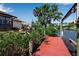 Waterfront home featuring a private dock with a boat lift, offering direct access to the canal for boating and scenic views at 9011 Hilolo Ln, Venice, FL 34293
