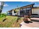 Beautiful exterior showing brick accents, many windows, well-maintained yard and adjacent outdoor deck at 9011 Hilolo Ln, Venice, FL 34293