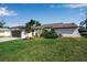 Charming single-story home with a well-manicured lawn, featuring a garage, lush landscaping, and a welcoming front entrance at 9011 Hilolo Ln, Venice, FL 34293