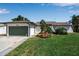 Charming home with a well-kept lawn, attached garage, and attractive landscaping at 9011 Hilolo Ln, Venice, FL 34293
