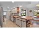 Bright kitchen featuring tile floors, natural light, countertops, and a wine rack below the breakfast bar at 9011 Hilolo Ln, Venice, FL 34293