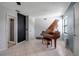 Bright living room featuring a grand piano and white tile flooring at 9011 Hilolo Ln, Venice, FL 34293