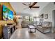 Comfortable living room featuring a large sectional sofa, entertainment center, and ceiling fan at 9011 Hilolo Ln, Venice, FL 34293