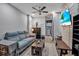 Comfortable living room featuring a large sofa, TV, and adjacent bathroom at 9011 Hilolo Ln, Venice, FL 34293