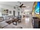Open-concept living room with comfortable seating, tile flooring and seamless flow into the dining area at 9011 Hilolo Ln, Venice, FL 34293