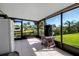 Enclosed patio with outdoor views, including a white refrigerator, generator and tiled floors at 9011 Hilolo Ln, Venice, FL 34293