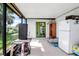 Screened in patio with tiled floor, white fridge and lake views at 9011 Hilolo Ln, Venice, FL 34293