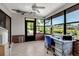 Sun room with tile floor, bright light and a water view, showcasing an organized workspace at 9011 Hilolo Ln, Venice, FL 34293