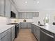 Bright kitchen features grey cabinets, stainless appliances, white countertops, and wood-look tile flooring at 9035 Duany Ln, Lakewood Ranch, FL 34240