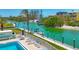Aerial view of waterfront condo featuring dock with boat lift, community pool, and lounging area at 9200 Midnight Pass Rd # 24, Sarasota, FL 34242