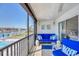 Inviting screened balcony with stylish blue furniture, tile flooring, and picturesque views of the waterfront at 9200 Midnight Pass Rd # 24, Sarasota, FL 34242