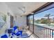 Charming screened balcony with cozy blue furniture, a ceiling fan, and beautiful water views at 9200 Midnight Pass Rd # 24, Sarasota, FL 34242