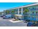 Exterior view of a multi-Gathering home with balconies, parking, and lush palm trees at 9200 Midnight Pass Rd # 24, Sarasota, FL 34242