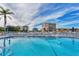 Resort-style pool with lounge chairs and umbrellas, offering stunning views of surrounding buildings and landscaping at 9200 Midnight Pass Rd # 24, Sarasota, FL 34242