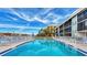 Sparkling community pool surrounded by lounge chairs, providing a relaxing and scenic outdoor space at 9200 Midnight Pass Rd # 24, Sarasota, FL 34242