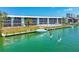 Waterfront building with boat dock and residents paddle boarding in bright turquoise water at 9200 Midnight Pass Rd # 24, Sarasota, FL 34242