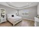Bedroom with tray ceiling, neutral colors, and wood floors at 10217 Canaveral Cir, Sarasota, FL 34241